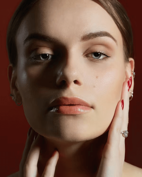 A woman displaying red nails and a ring while discussing botox benefits