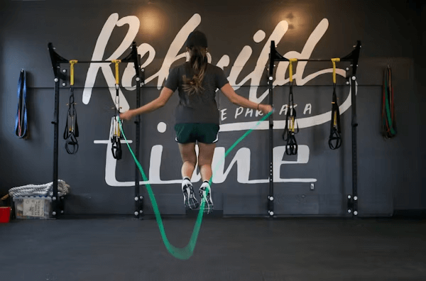 Woman jumping rope in gym for holiday fitness