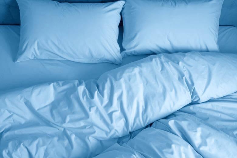 Blue bed with no-bunching duvet cover and pillows