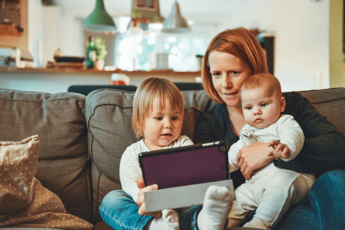 Woman balancing work and family holding baby and tablet