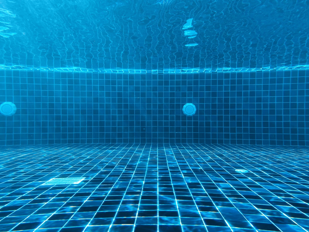 Clean blue tiled swimming pool with clear water