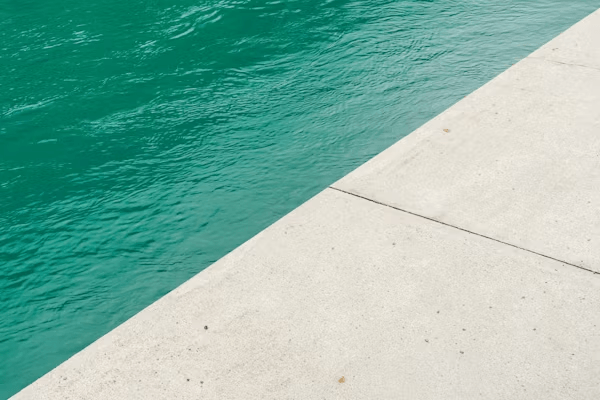 Person standing by a green pool, ready to