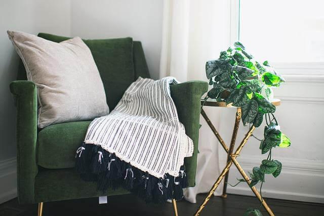 Green chair with a white blanket, adding
