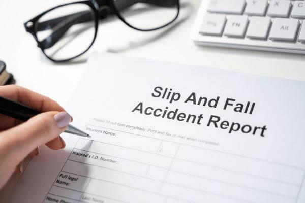 Person signing a slip and fall accident report in