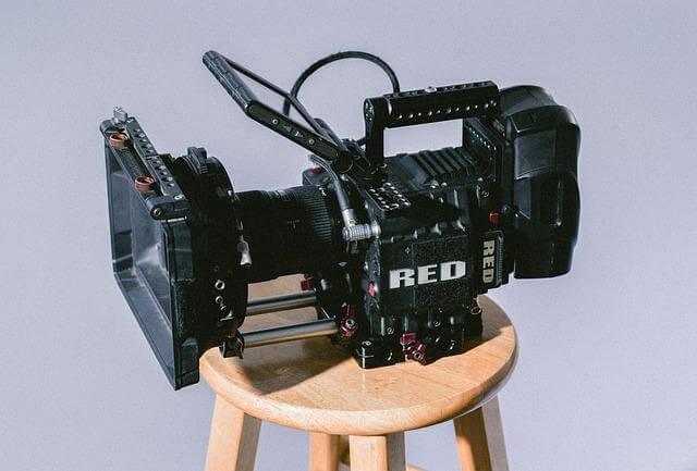 Red camera for video production on a wooden stool