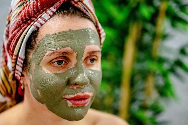 Woman with green facial mask symbolizing skincare