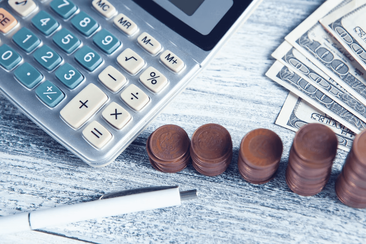 Calculator, pen, and money representing business