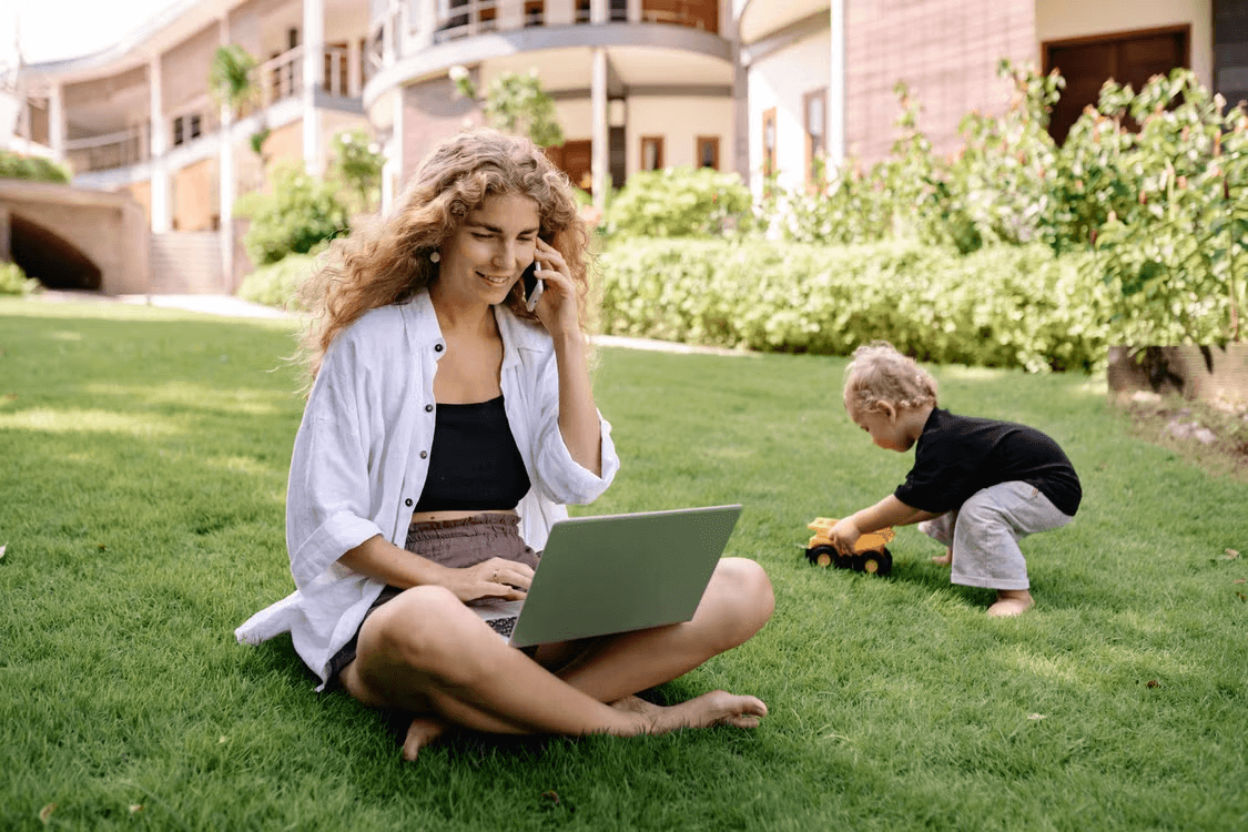 Mom entrepreneur on grass talking on cell phone