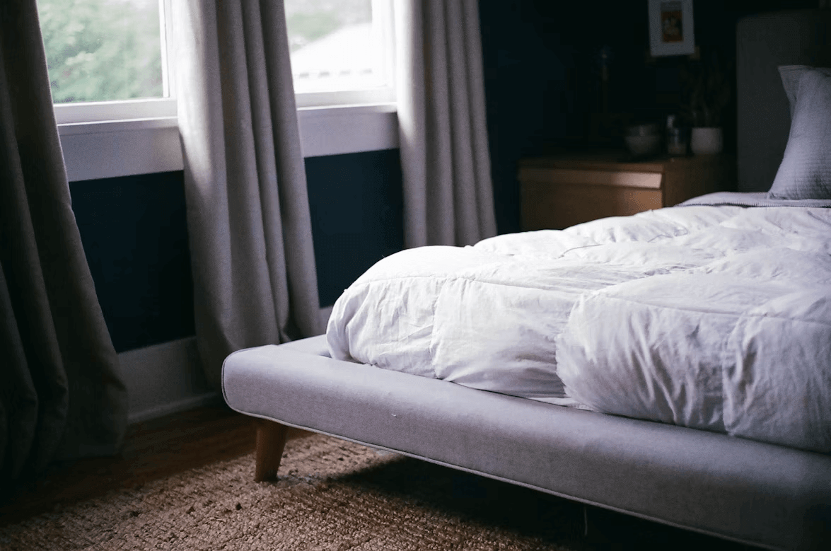 White bed with cooling bedding in a bright bedroom