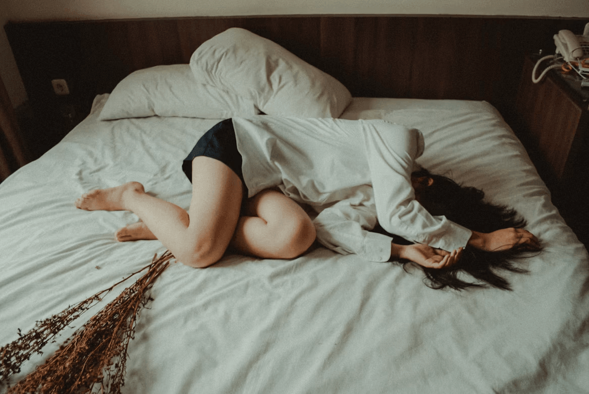 Woman resting on a bed with dried flowers