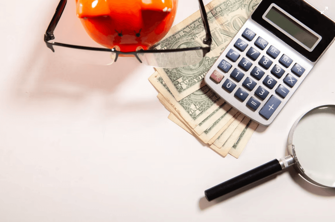 calculator, magnifying glass, and money illustrating