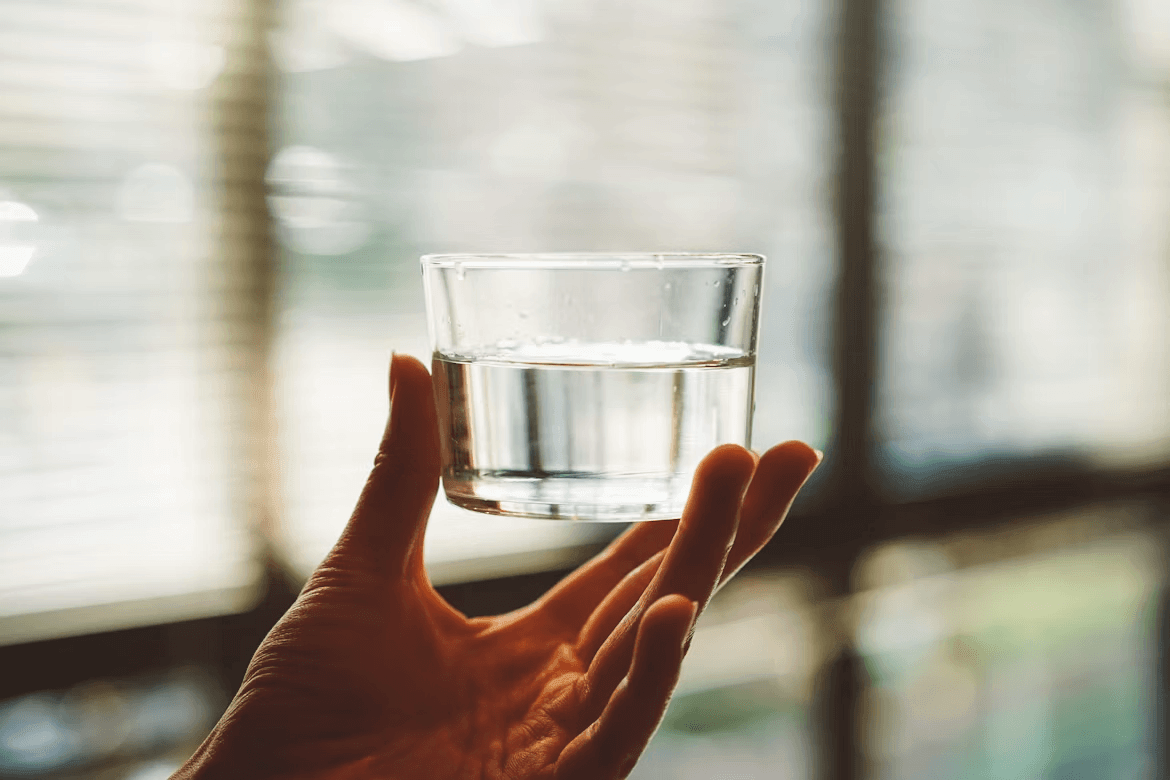 Hand holding a glass of water, an easy habit