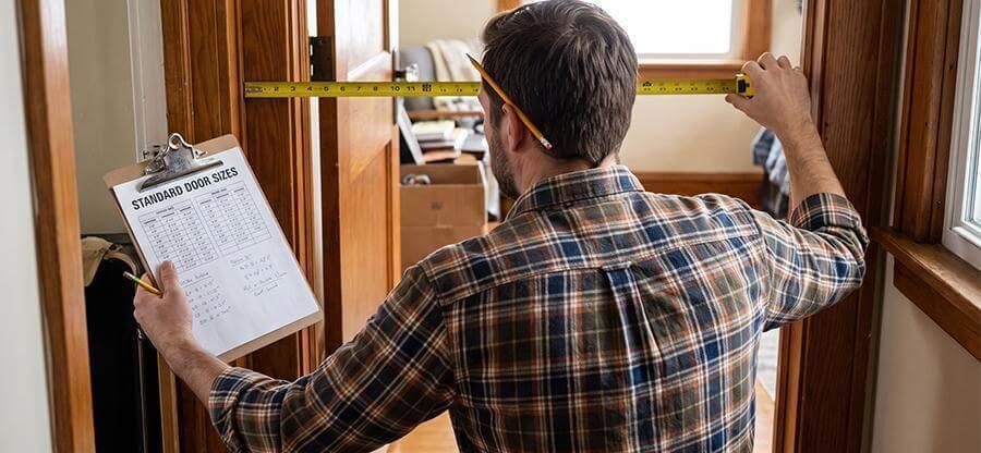 Man holding clipboard with a measuring tape, likely measuring