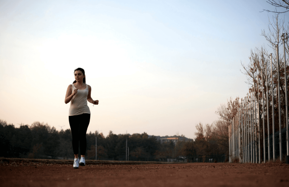 Woman running on a dirt road, symbolizing
