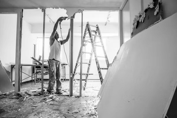 Remodeling contractor evaluating a room with a ladder