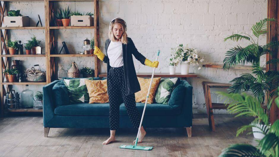Woman cleaning living room floor with a