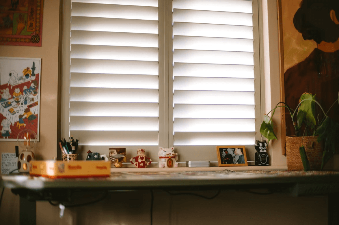 A small table with a potted plant and framed pictures