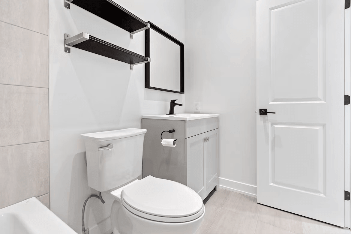 A white toilet next to a sink in a bathroom