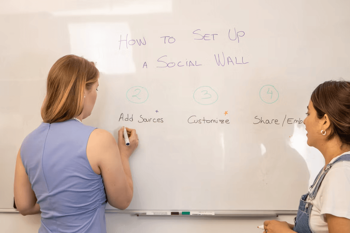 Two women collaborating on a whiteboard in