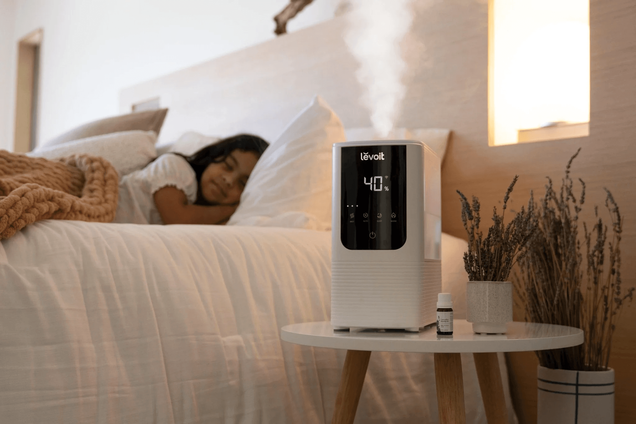 Woman relaxing in bed next to a humidifier