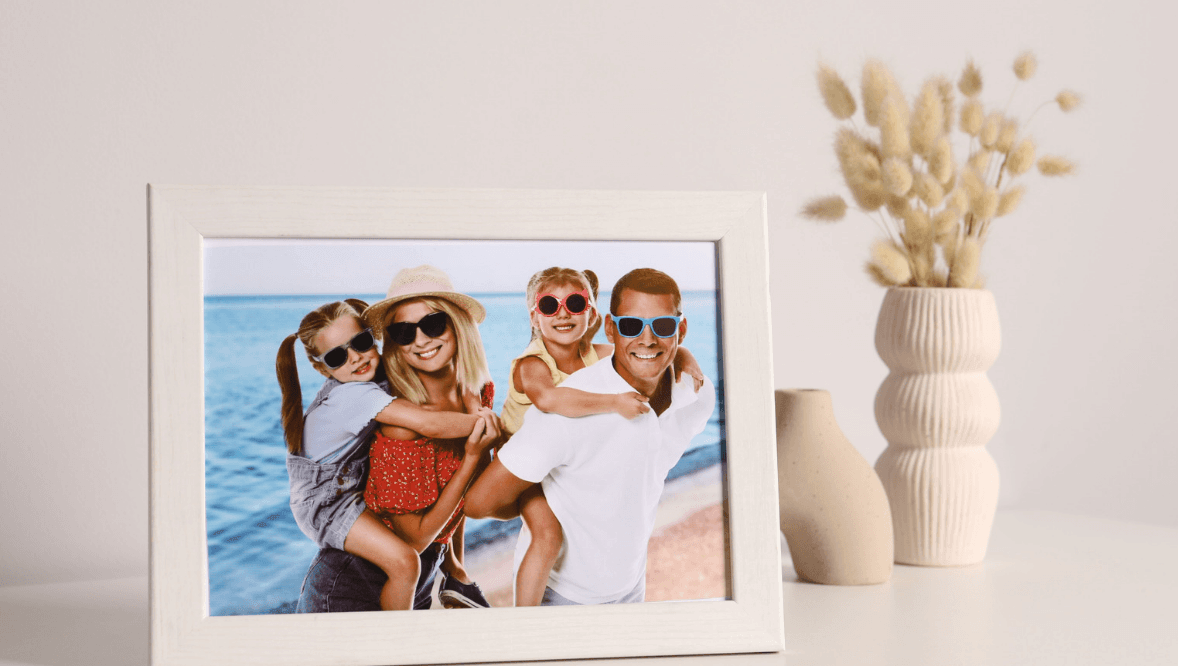 Picture frame with a family photo next to a vase