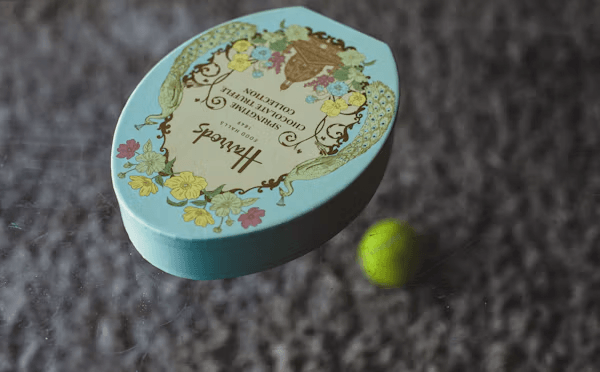 Small blue gift box next to a tennis