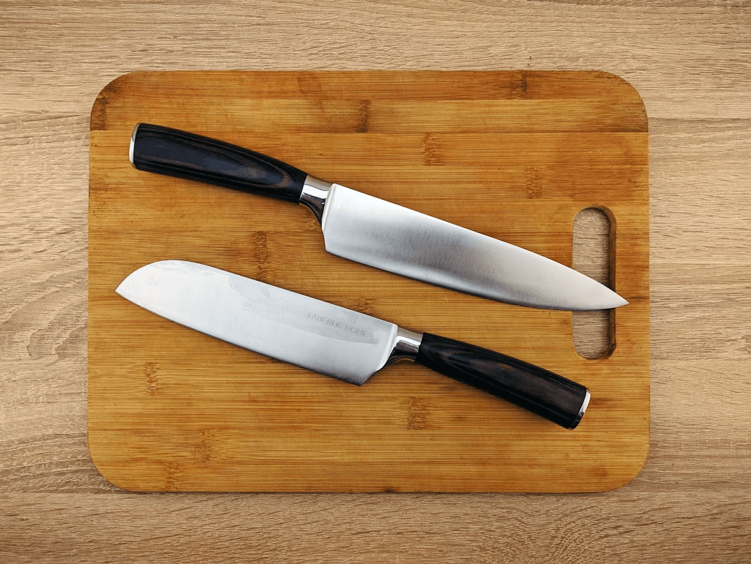 Two essential kitchen knives resting on a wooden cutting